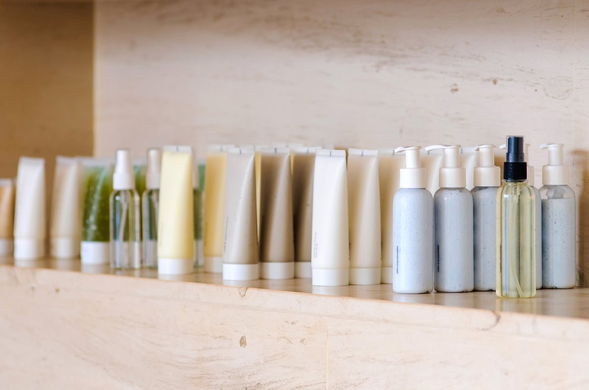 Esstainals skincare products on marble shelf